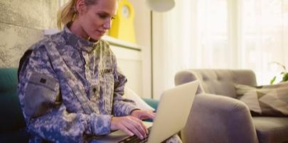 Student in Military Uniform Using a Laptop