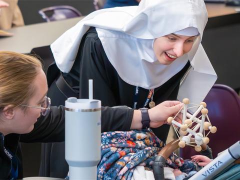 Sister playing with a baby on break during the Montessori Conference